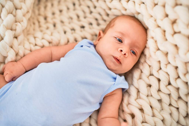 Adorable baby lying down on the sofa over blanket at home. Newborn relaxing and resting comfortable - Foto, Imagen