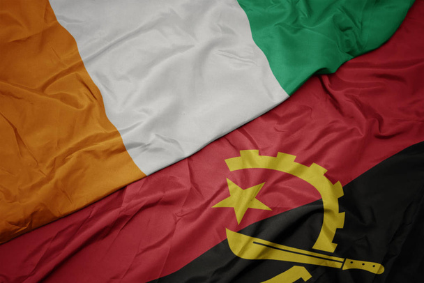 machanie kolorowa flaga angoli i flaga narodowa cote divoire. - Zdjęcie, obraz