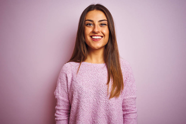 Mujer hermosa joven con suéter casual de pie sobre un fondo rosa aislado con una sonrisa feliz y fresca en la cara. Persona afortunada
. - Foto, Imagen