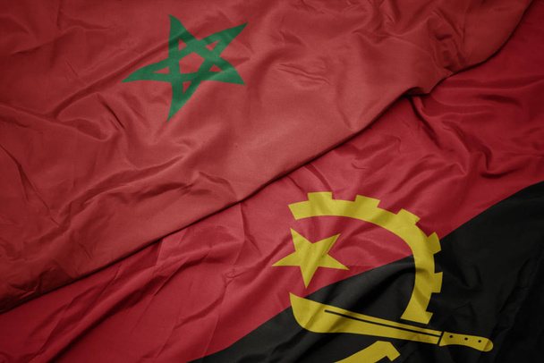 κυματίζει πολύχρωμη σημαία της Αγκόλας και εθνική σημαία του Μαρόκου. - Φωτογραφία, εικόνα