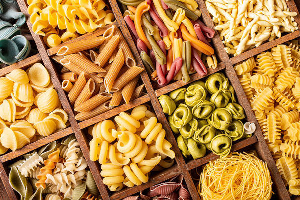 Assorted colorful italian pasta in wooden box - Photo, image