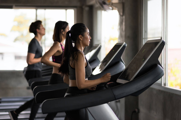 Group of friends run treadmills in gym - Photo, Image