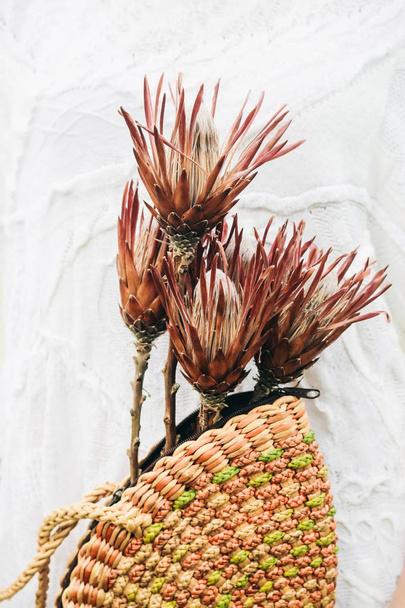 Цветы Протеуса в плетеной корзине. Экологическая сумка с экзотическими цветами
 - Фото, изображение