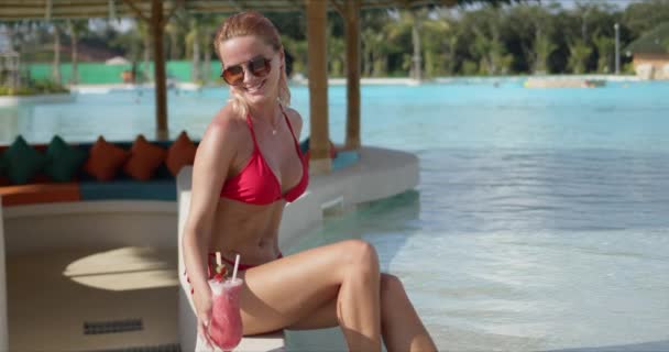 Happy woman with cocktail resting on poolside - Materiaali, video