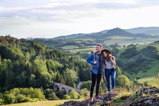 Young tourist couple travellers with backpacks hiking in nature, resting. - 写真・画像
