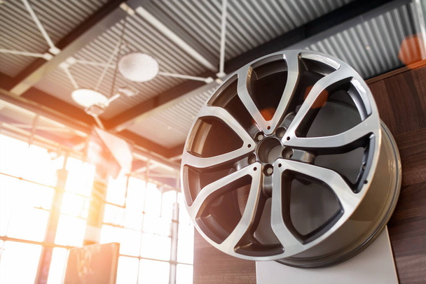 Modern alloy car drive on a background of sunny sunset. The concept of buying stylish wheels on a car, new, copy space - 写真・画像