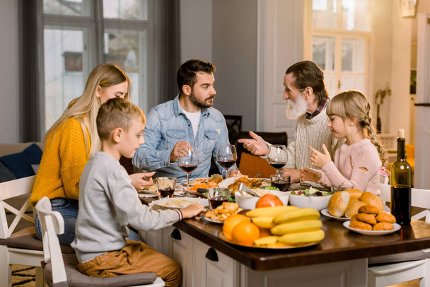 Familia con niños comiendo cena de Acción de Gracias. Pavo asado y pasta, ensalada y frutas en la mesa de comedor. Comida festiva para padres e hijos
. - Foto, Imagen