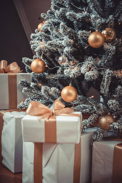 Mutlu noeller. Noel ağacının yanında hediyeler var. Sarı ve altın renkli fotoğraf. - Fotoğraf, Görsel