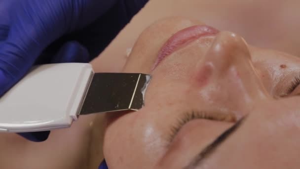 Ammattimainen kosmetologi tekee ultraääni kasvojen puhdistus keski-ikäinen nainen
. - Materiaali, video