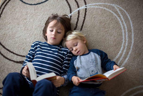 Schattig kind, jongen, thuis een boek lezen - Foto, afbeelding