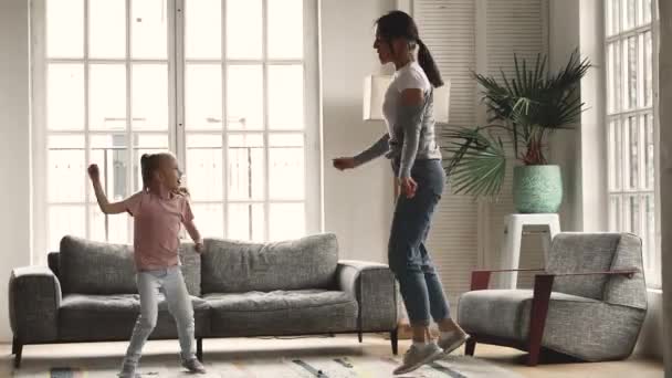 Funny young mum and child daughter having fun dancing together - Felvétel, videó