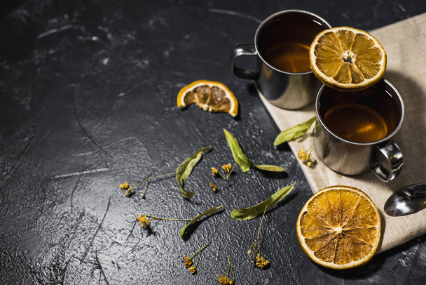 cup of healthy black indian lemon tea and citruses - Foto, afbeelding