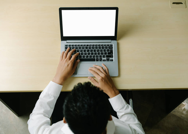 Business person or office worker using laptop computer while sitting at desk. - 写真・画像