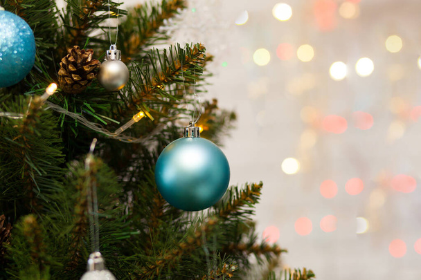 Krásný zelený vánoční stromek zdobený kuličkami a girlandami. Fotografie zblízka. Jiskřivé pozadí - Fotografie, Obrázek