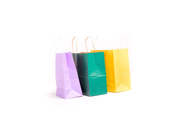 Birçok renkli alışveriş torbası beyaz zeminde tek başına duruyor.. - Fotoğraf, Görsel