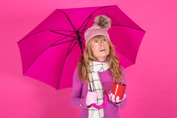 woman with coffee cup and umbrella on color background - Foto, Imagen