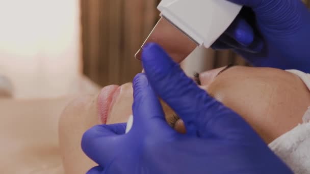 Professzionális kozmetikus ultrahangos arctisztítást végez középkorú nők számára. - Felvétel, videó