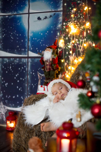 Όμορφο μικρό παιδί, αγοράκι, κοιμάται την παραμονή των Χριστουγέννων στο  - Φωτογραφία, εικόνα