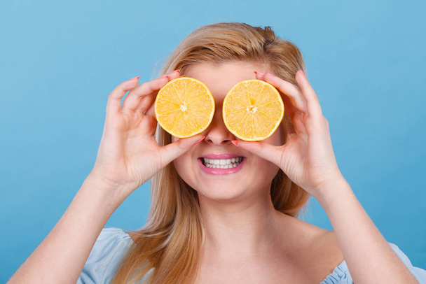 Girl covering her eyes with lemon citrus fruit - Foto, imagen