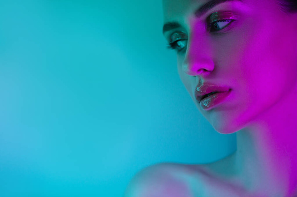 High Fashion woman in colorful bright neon uv blue and purple lights, posing in studio - Foto, imagen