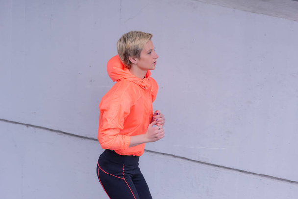 Running woman. Female fitness model training outside in the city. - Photo, Image