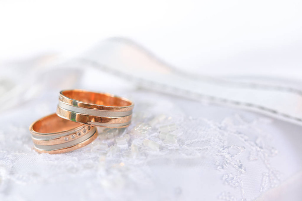 Dos anillos de boda de bronce en textil blanco
 - Foto, imagen