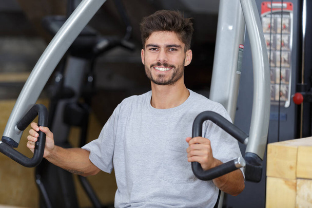 portrait of young man using gym equipment - Photo, Image