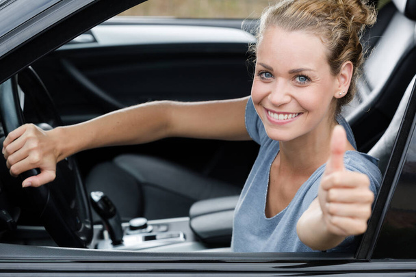 cute woman giving thumb up inside her car - Valokuva, kuva