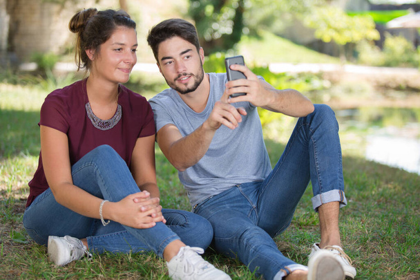 lovely couple taking a selfie in the park - Foto, imagen