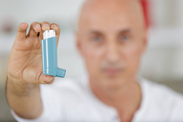 showing a inhaler and man - Foto, Bild