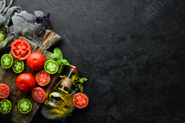 Vegetables. Fresh colored tomatoes On a black stone background. Top view. Free space for your text. - Valokuva, kuva