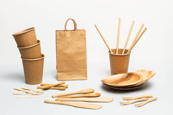 Copos descartáveis, pratos e utensílios de cozinha em um fundo cinza
 - Foto, Imagem