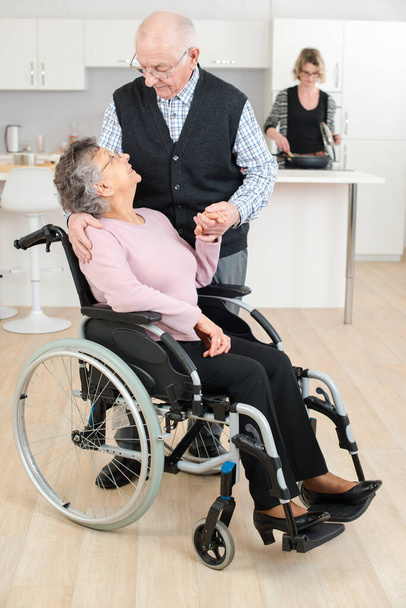 senior man touching woman in wheelchair - Fotoğraf, Görsel