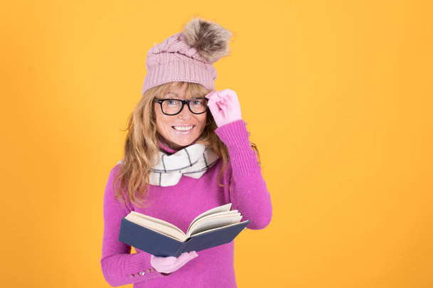adult woman or girl with book and winter clothes isolated on color background - Фото, изображение