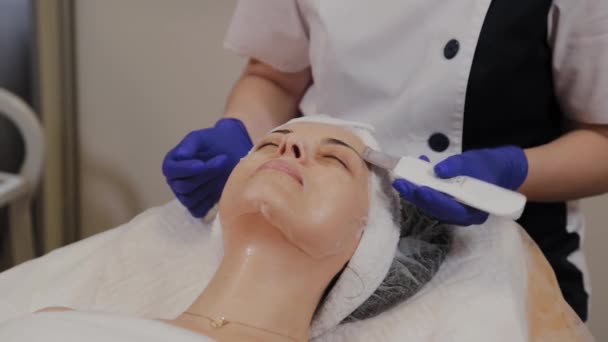 Profesionální kosmetička provádí ultrazvukové čištění obličeje pro ženy středního věku. - Záběry, video