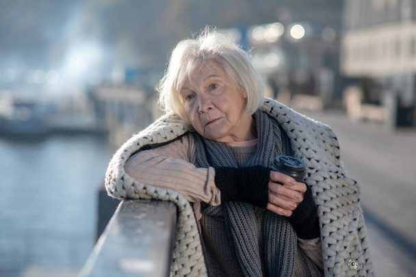 Poor homeless woman feeling thoughtful while staying alone - 写真・画像