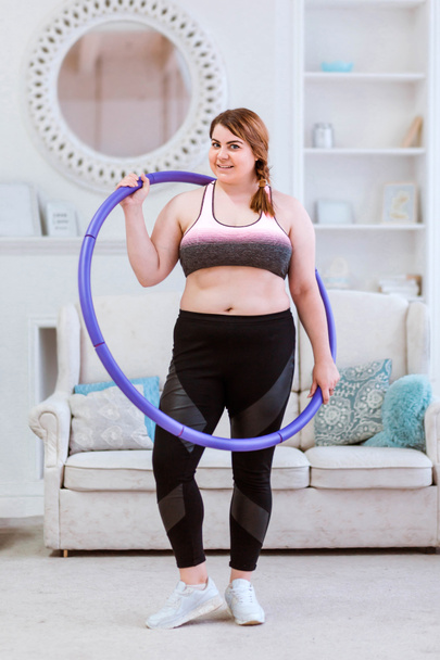 The model is a fat woman, trying to lose weight at home and doing exercises with halajup - Photo, Image