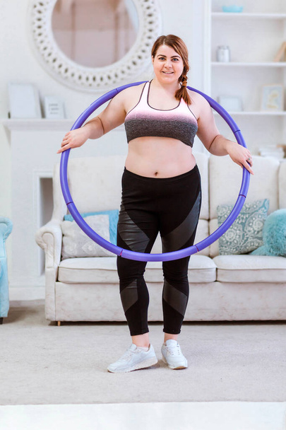 The model is a fat woman, trying to lose weight at home and doing exercises with halajup - Foto, Imagem