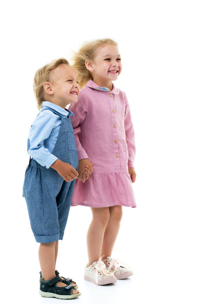 ein Mädchen und ein Junge, Bruder und Schwester freuen sich im Wind, der blo - Foto, Bild