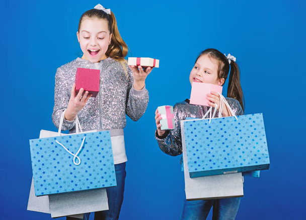Kids fashion. Girls sisters friends with shopping bags blue background. Every product delivered to you. Shopping and purchase. Black friday. Sale and discount. Children bunch packages. Shopping day - Φωτογραφία, εικόνα