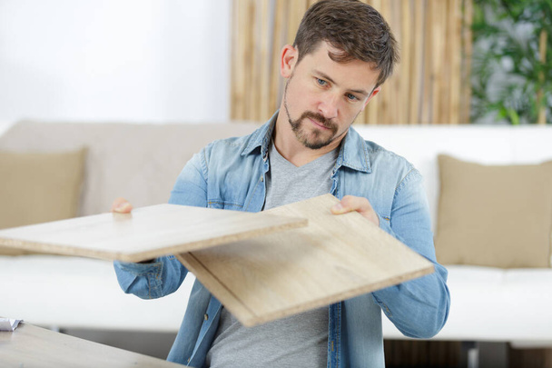 man assembling furniture in new house - Фото, изображение