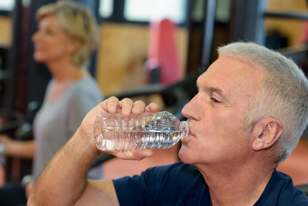 middle age man driking bottled water - 写真・画像