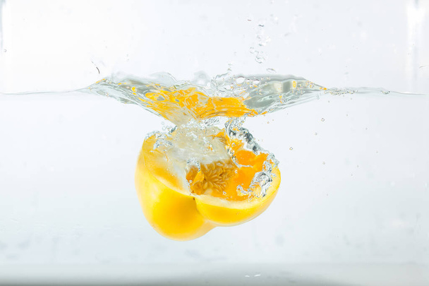 Sweet pepper in the water splashes, the yellow Sweet pepper on a white background. Sweet peppers are a type of pepper. Not spicy - Fotoğraf, Görsel