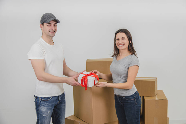 Courier delivered present for young woman who is moving into new apartment. Woman is really happy. - 写真・画像