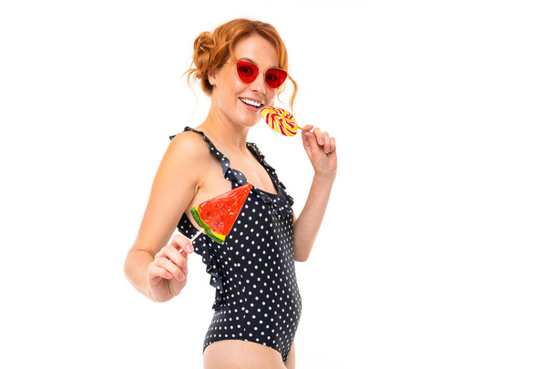 young woman in sunglasses posing with candies against white background   - 写真・画像