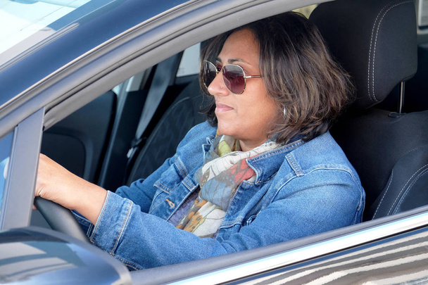 cincuenta y cinco años de edad mujer asiática conducir un coche de alquiler
 - Foto, imagen