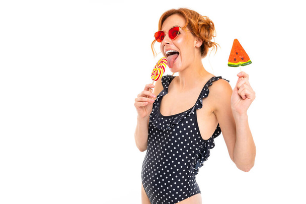 молода жінка в сонцезахисних окулярах позує з цукерками на білому тлі
   - Фото, зображення