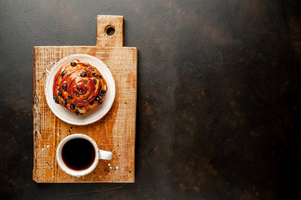 taza y café con producto de panadería sobre un fondo oscuro
 - Foto, imagen