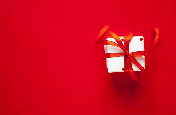 joululahja laatikko punainen nauha punaisella taustalla
  - Valokuva, kuva