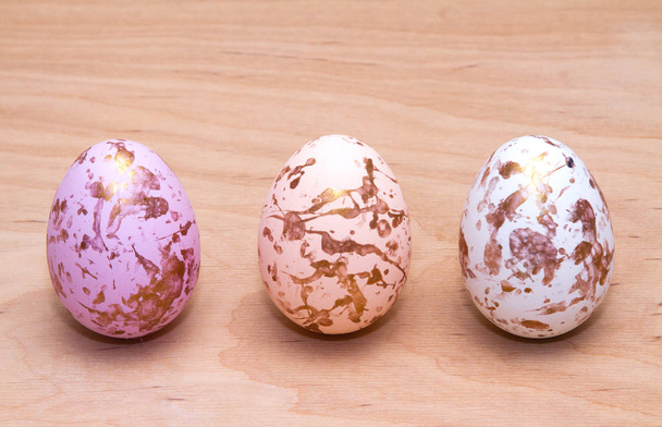 Velikonoční vajíčka ve zlaté barvě na dřevěném stole. Krásné náboženské pozadí.  - Fotografie, Obrázek